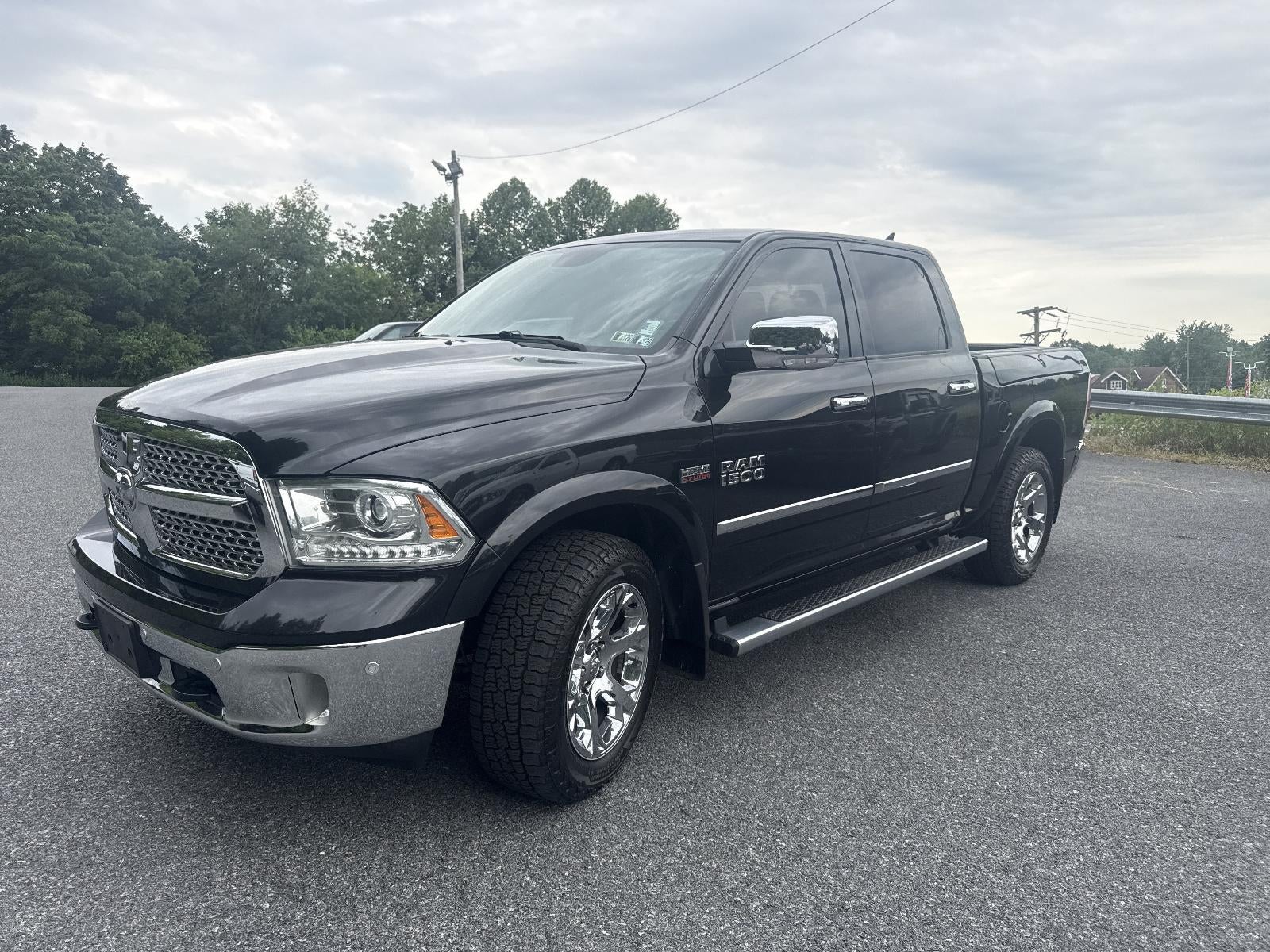 2017 RAM 1500 Laramie 4x4 Crew Cab 5'7" Box in Brilliant Black Crystal Pearlcoat — front three-quarter view